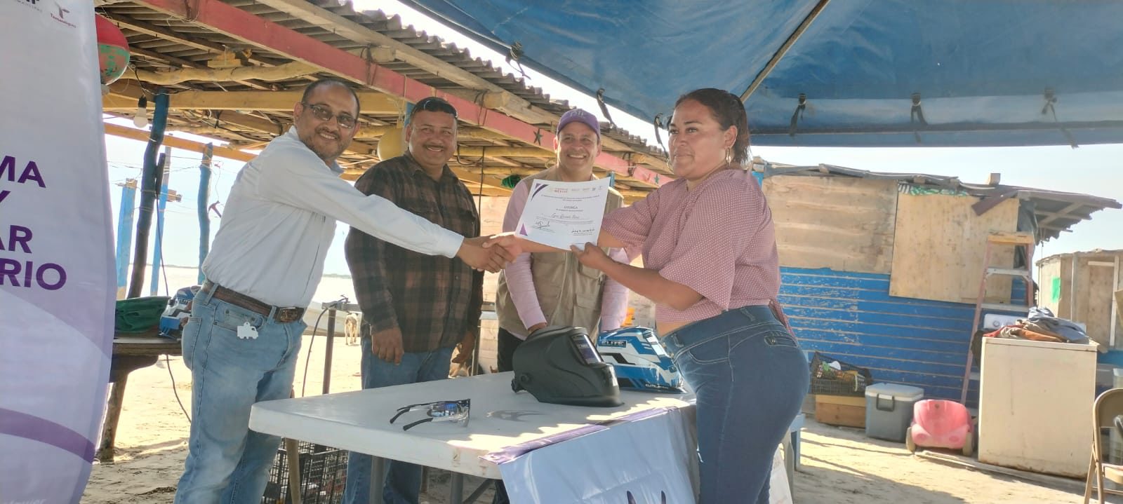 Entrega de certificado a un participante del taller de soldadura